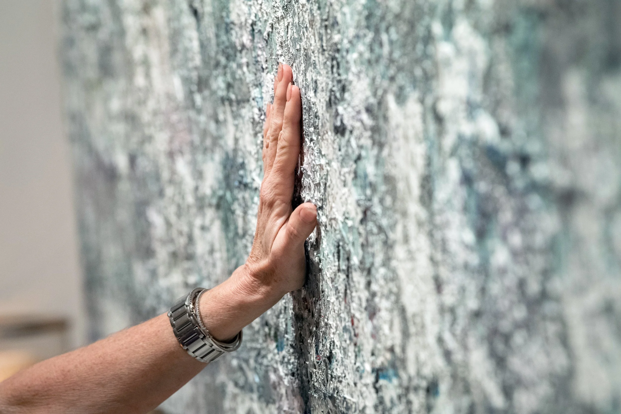 Laura Roosevelt’s hand resting on the surface of a painting